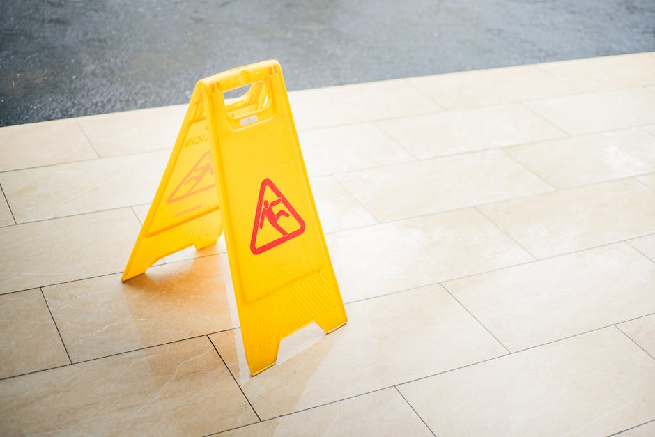 Four white square tiles with black letters spelling 'HTML' are arranged in a straight horizontal line on a smooth, coral-colored surface. The tiles are evenly spaced, with a subtle shadow beneath each